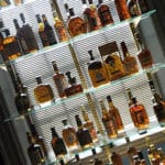 Bourbon bar display and storage of glass shelving, mirrored back-wall and a wide variety of bourbon