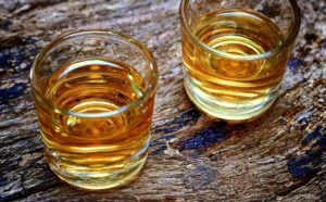 Two glasses of bourbon on wooden table