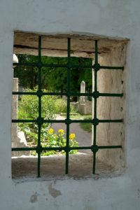 View of old cemetery through barred window